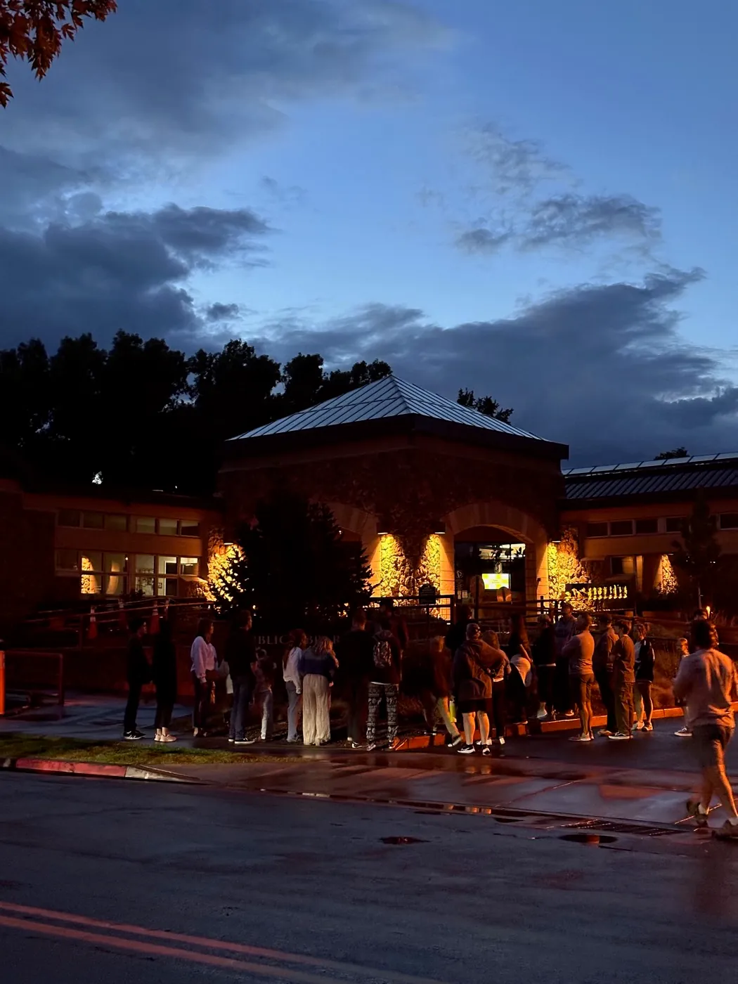 Guests photographing a historic Flagstaff building at night on the tour