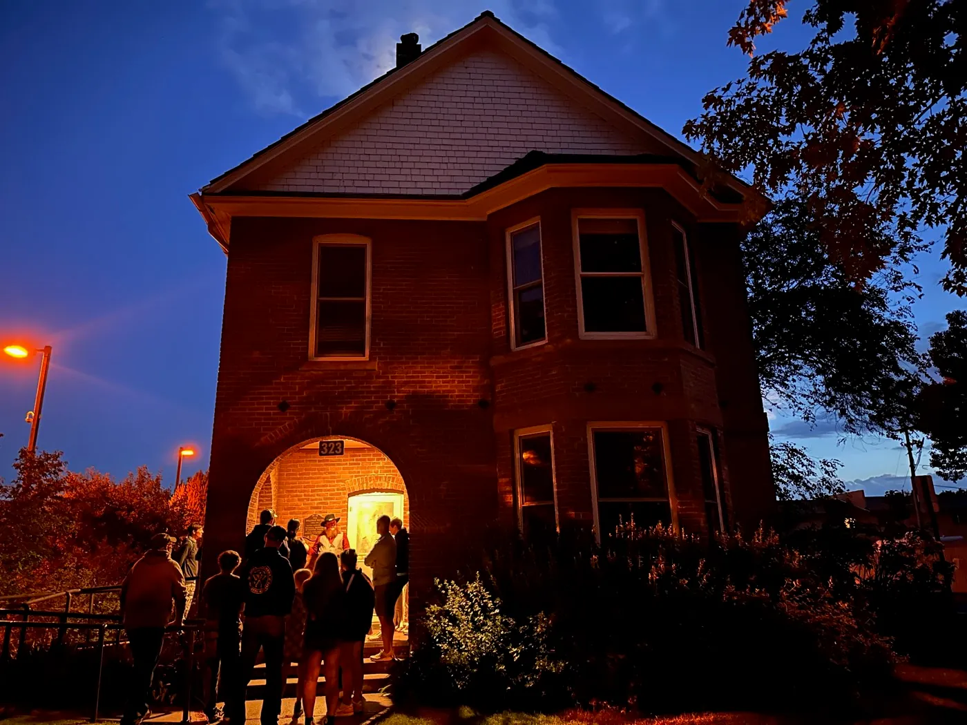 A Freaky Foot Tours group gathered at a historic Flagstaff house archway at night